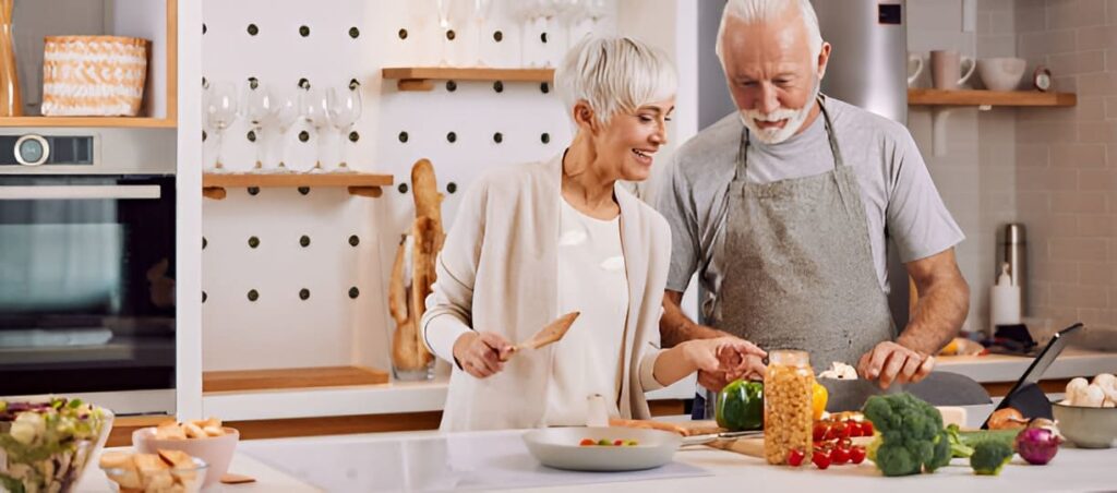 Old couple cooking vegetables happily in a modern kitchen