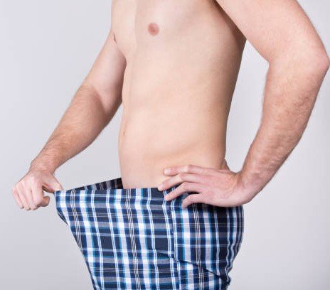 a man trying to look into his pants
